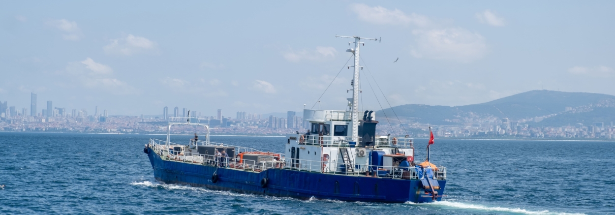 Buque de trabajo comercial navegando en aguas portuarias — embarcación con sistemas de gestión de combustible y refueling naval a bordo