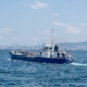 Buque de trabajo comercial navegando en aguas portuarias — embarcación con sistemas de gestión de combustible y refueling naval a bordo